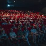 Audience seated in a theater for a live music and entertainment event