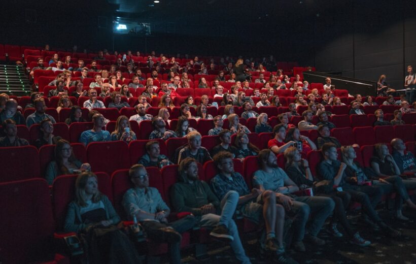 Audience seated in a theater for a live music and entertainment event